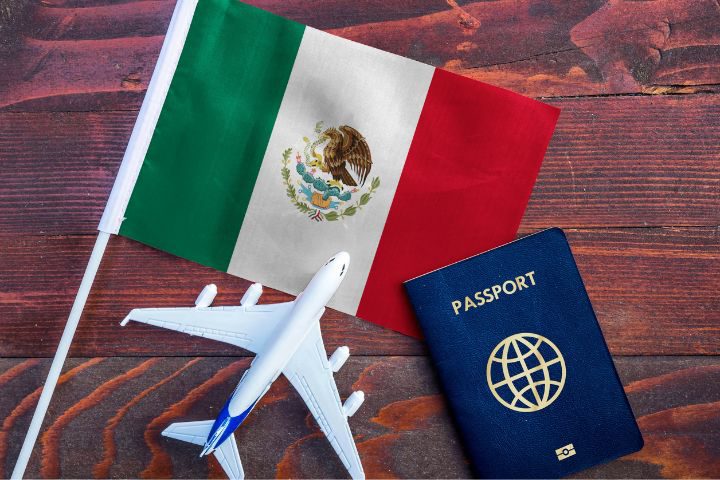 メキシコ国旗とパスポートと飛行機のおもちゃのイメージ