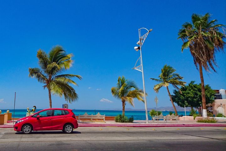 メキシコの海岸沿いを走る車のイメージ