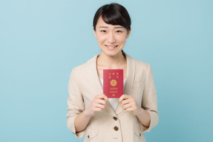 パスポートを持つスーツ姿の女性の画像