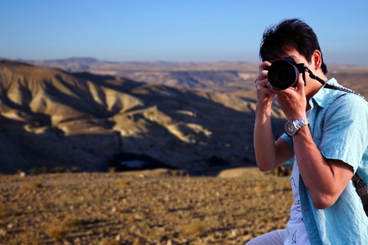 山頂で撮影しているカメラマンのイメージ