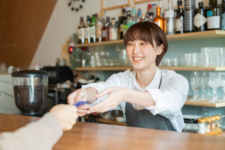 カフェで接客している若い日本人女性の画像