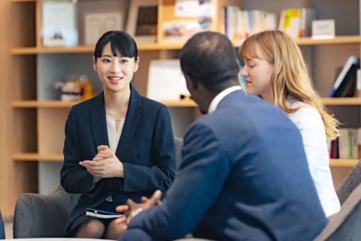 日本人と外国人がビジネスの場で座って会話している様子