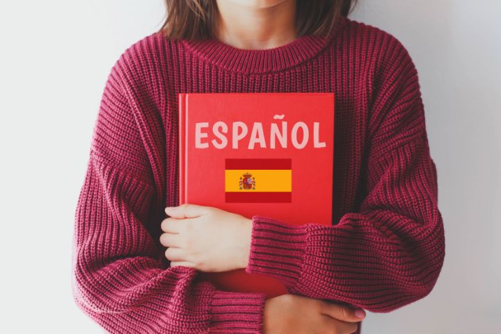 ESPANOLと書かれた本を抱える人の画像