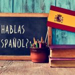 スペイン語が書かれた黒板とスペイン国旗の画像