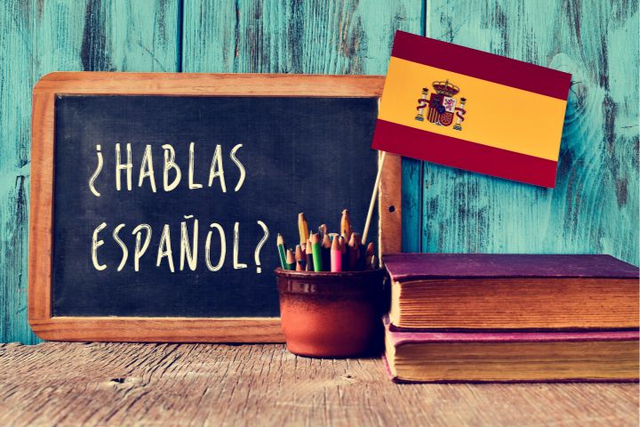 スペイン語が書かれた黒板とスペイン国旗の画像